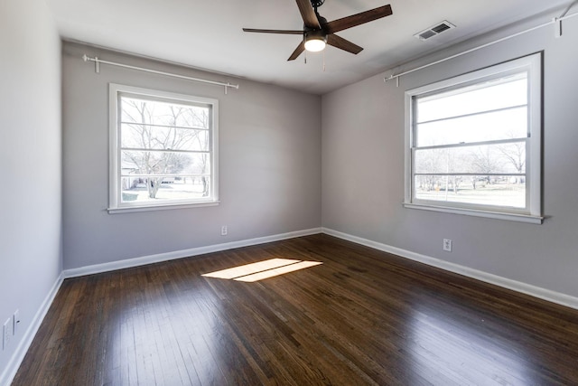 unfurnished room with baseboards, visible vents, ceiling fan, and hardwood / wood-style floors