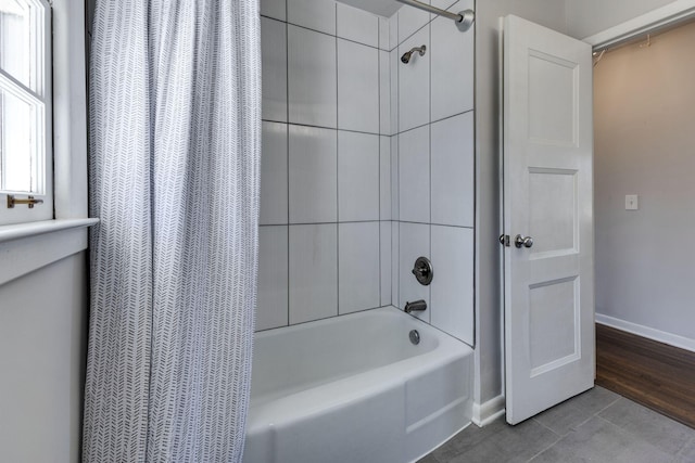 full bathroom with shower / tub combo and baseboards