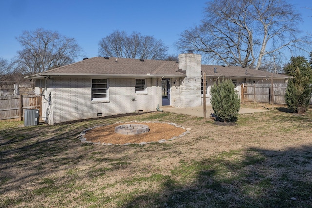 rear view of house with central AC, brick siding, fence, a chimney, and a patio area