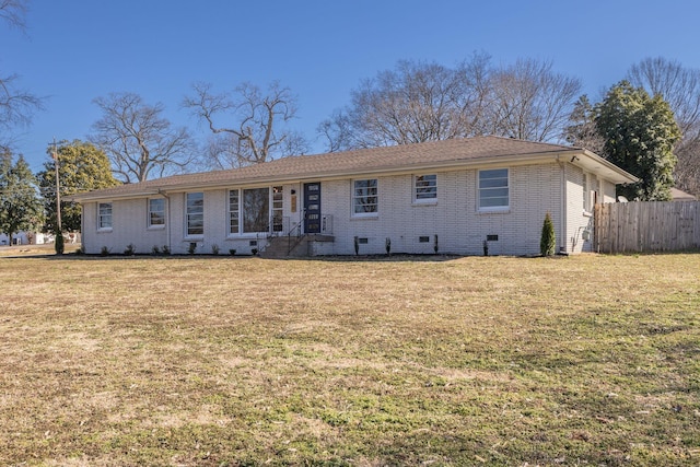 rear view of property with a yard, brick siding, crawl space, and fence