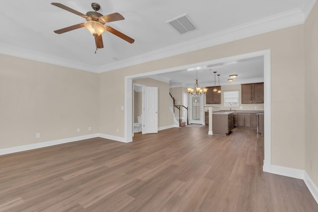 unfurnished living room with ornamental molding, wood finished floors, visible vents, and baseboards