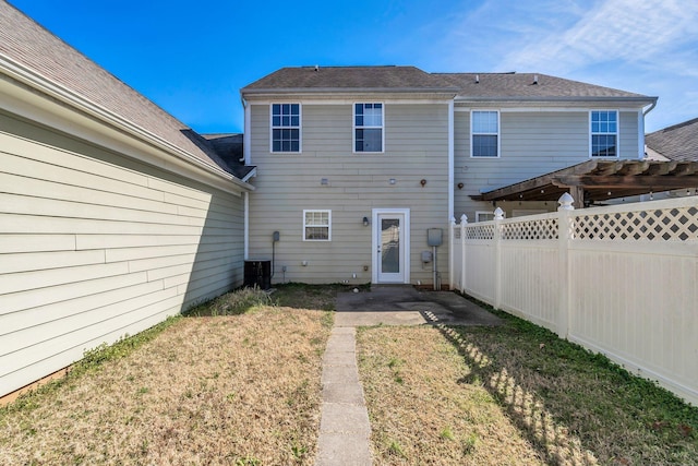 rear view of house featuring a fenced backyard, a yard, a patio, and a pergola