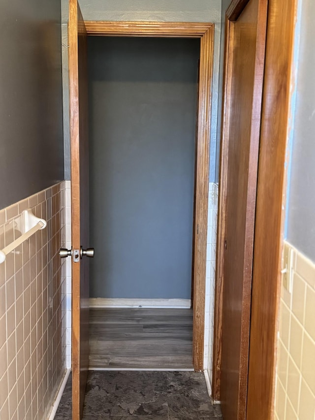 hallway with a wainscoted wall and tile walls