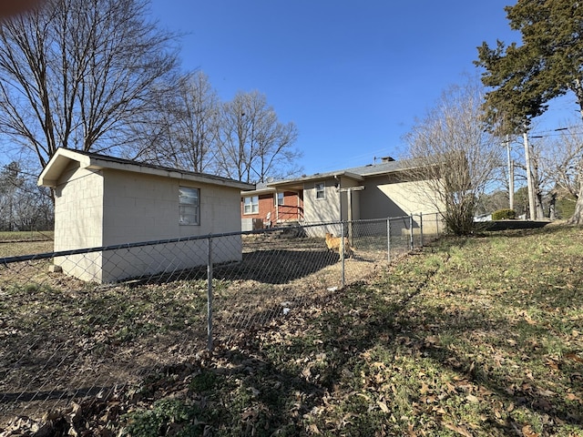 view of side of home with concrete block siding and fence