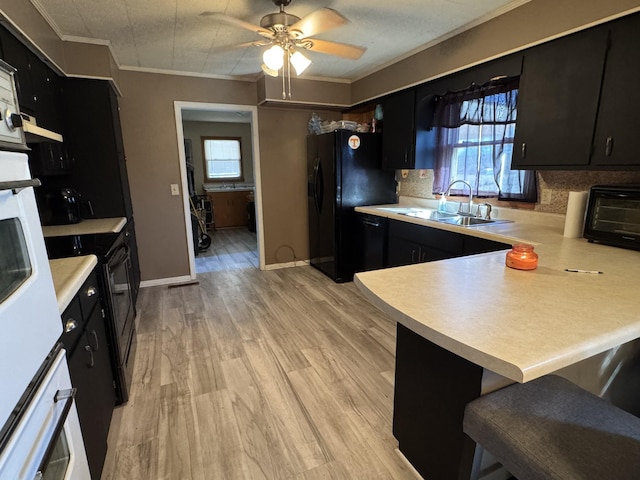 kitchen featuring black appliances, light countertops, and dark cabinets