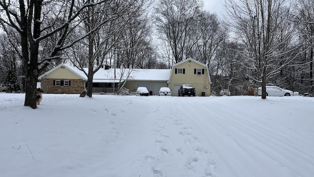 view of front of home featuring a detached garage and a gambrel roof