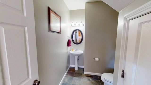 bathroom featuring baseboards and toilet