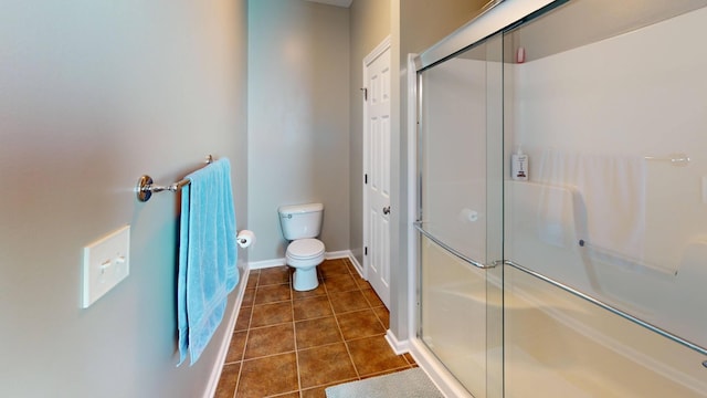 full bath featuring baseboards, toilet, a shower stall, and tile patterned flooring