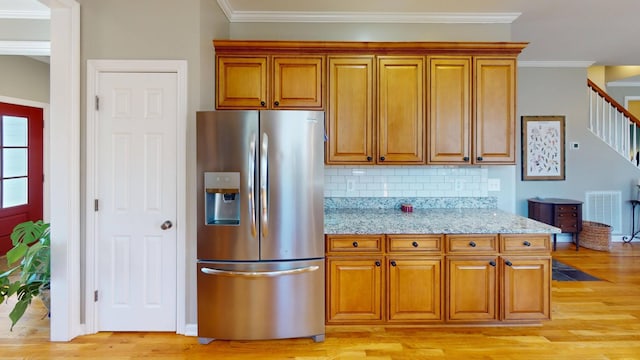 kitchen featuring brown cabinets, light wood-style floors, ornamental molding, and stainless steel refrigerator with ice dispenser