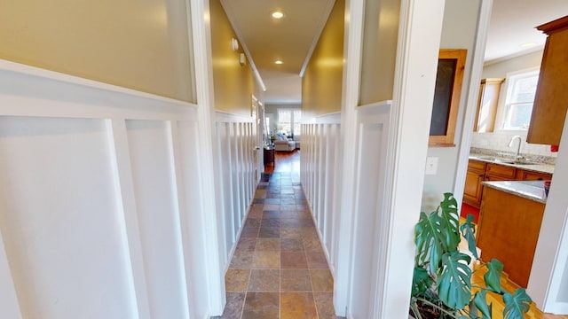 corridor featuring a sink, recessed lighting, and stone finish floor