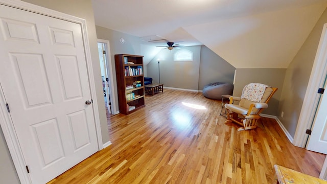 sitting room with lofted ceiling, a ceiling fan, light wood-type flooring, and baseboards