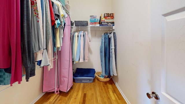 walk in closet with wood finished floors