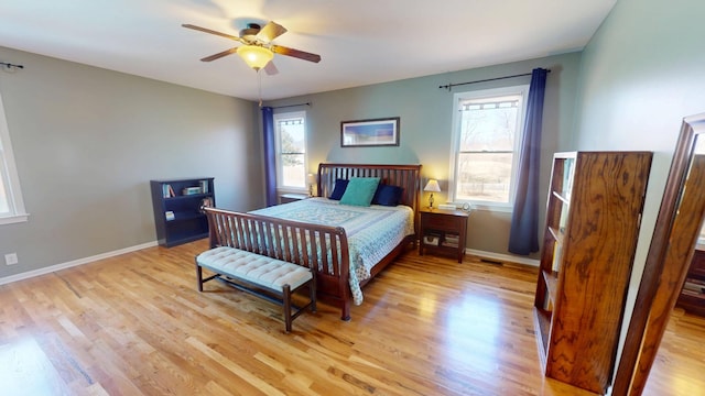 bedroom featuring light wood finished floors, a ceiling fan, and baseboards