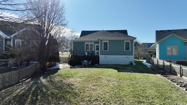 rear view of property featuring crawl space, a yard, and a fenced backyard