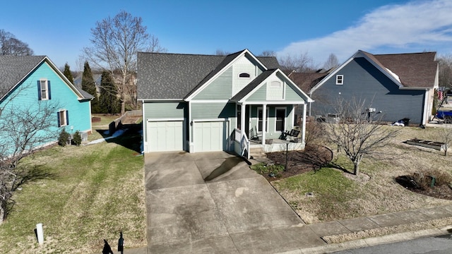 view of front facade with a porch, a shingled roof, driveway, and a front yard