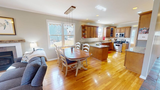 dining room with recessed lighting, light wood-style floors, ornamental molding, and a fireplace