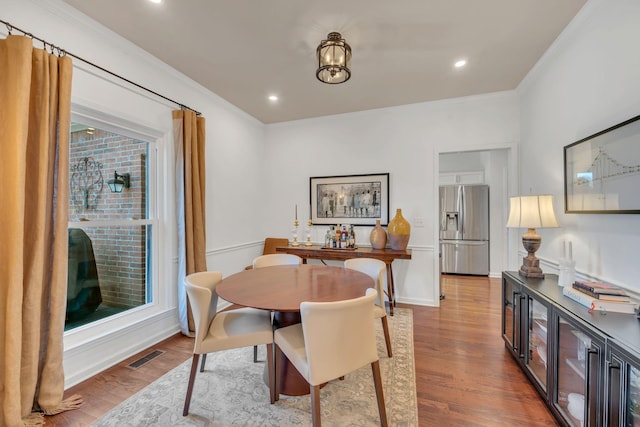 dining area with ornamental molding, recessed lighting, visible vents, and wood finished floors