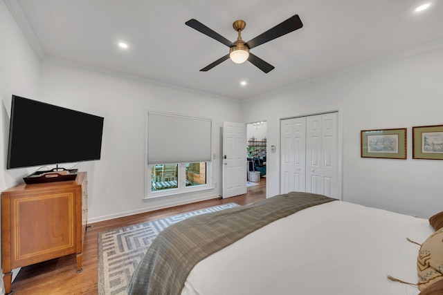 bedroom featuring a ceiling fan, light wood-style flooring, ornamental molding, a closet, and recessed lighting