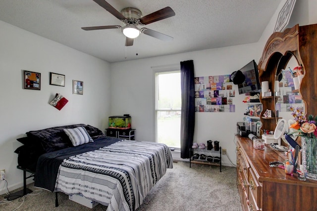 bedroom with light carpet, a ceiling fan, and a textured ceiling