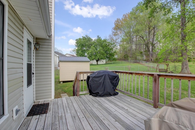 deck with an outbuilding, a yard, area for grilling, fence, and a shed