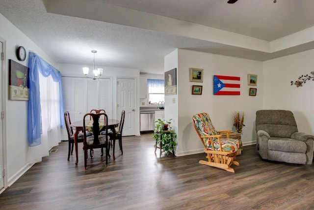 dining area featuring dark wood finished floors, a textured ceiling, baseboards, and ceiling fan with notable chandelier