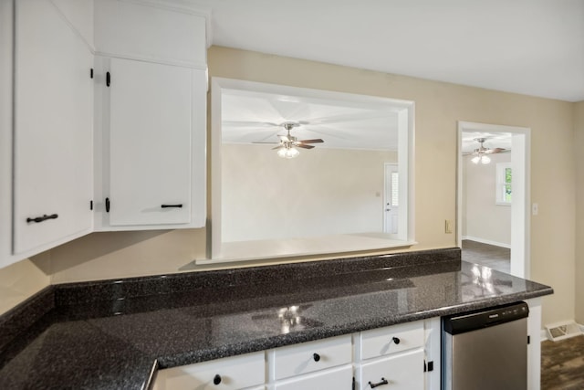 kitchen featuring a ceiling fan, white cabinets, visible vents, and dark stone countertops