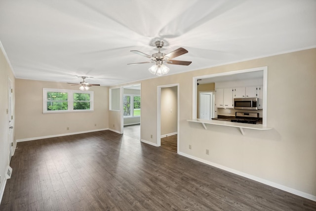 unfurnished living room featuring dark wood-style floors, ceiling fan, baseboards, and crown molding