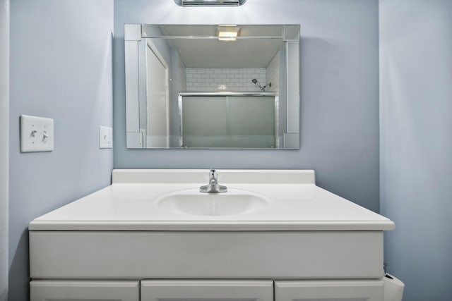 bathroom featuring a shower and vanity