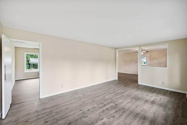 spare room featuring baseboards and wood finished floors