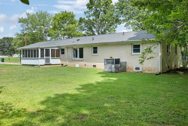 rear view of property with a sunroom, crawl space, a lawn, and central air condition unit