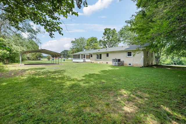 view of yard featuring a sunroom and a detached carport