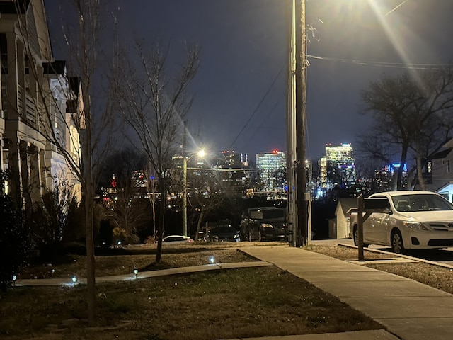 view of street with sidewalks and a view of city lights