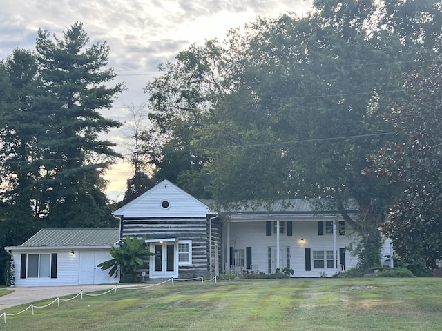 view of front of house with a garage, a front yard, french doors, and metal roof