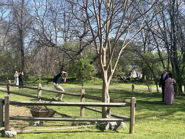 view of home's community with a yard and fence