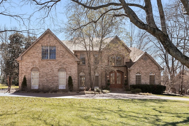 view of front of property featuring french doors, a front lawn, and brick siding