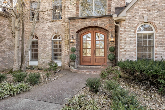 view of exterior entry with french doors and brick siding