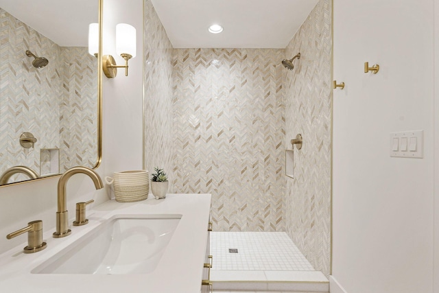 bathroom with recessed lighting, tiled shower, and vanity