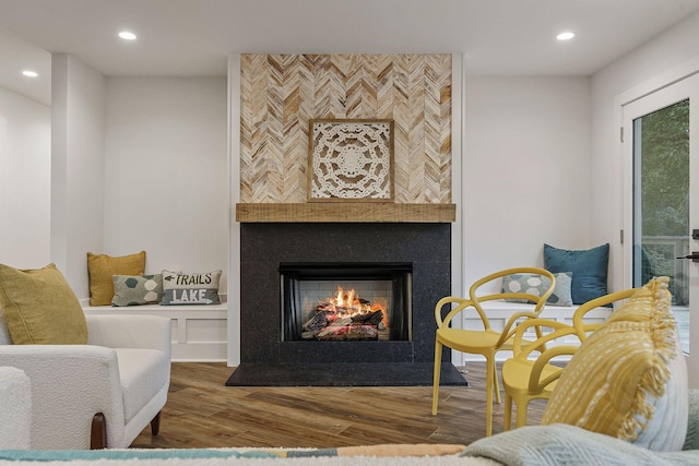 living area with a tile fireplace, wood finished floors, and recessed lighting