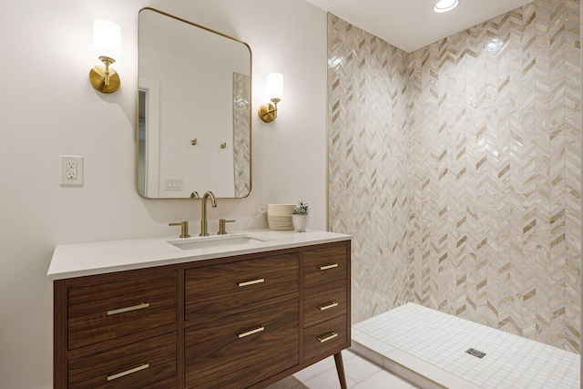 bathroom featuring a tile shower and vanity