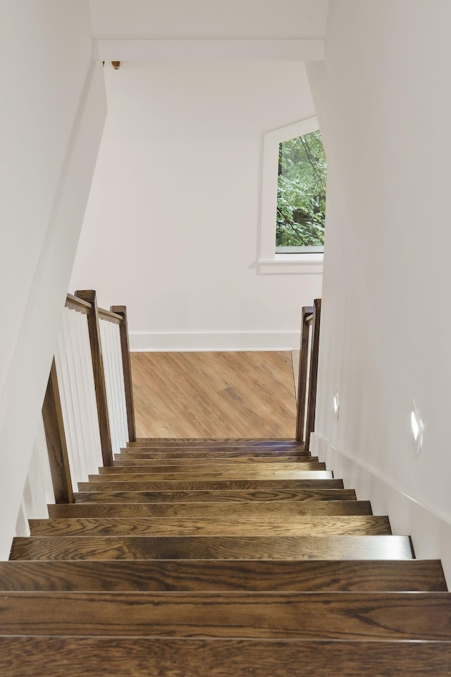 staircase with wood finished floors and baseboards