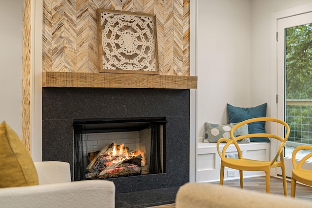 interior space with a lit fireplace and wood finished floors