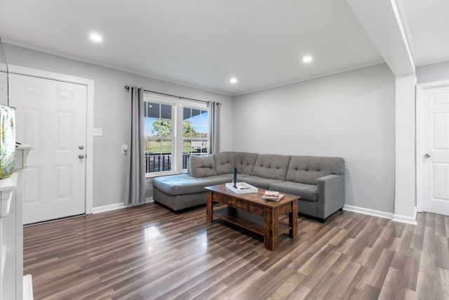 living room featuring crown molding, baseboards, wood finished floors, and recessed lighting