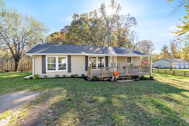 ranch-style house with covered porch, fence, roof with shingles, a front lawn, and a chimney