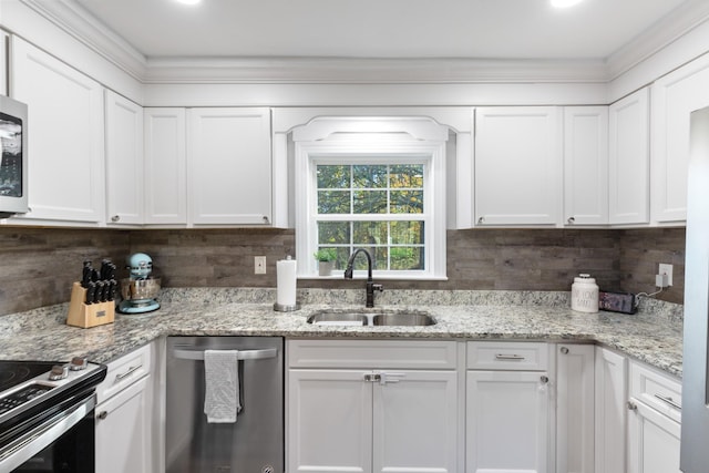 kitchen featuring stainless steel appliances, backsplash, a sink, and white cabinetry