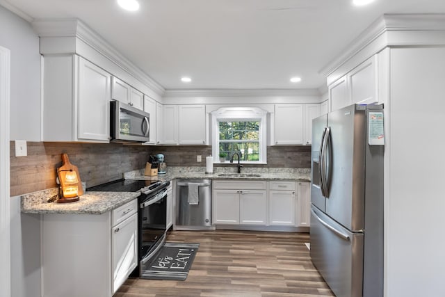 kitchen featuring stainless steel appliances, white cabinetry, and a sink