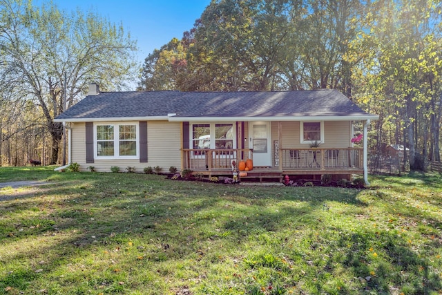 ranch-style home with a porch, a shingled roof, a chimney, and a front lawn