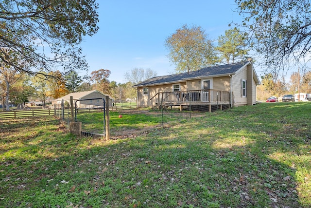 back of property featuring a deck, a yard, and fence