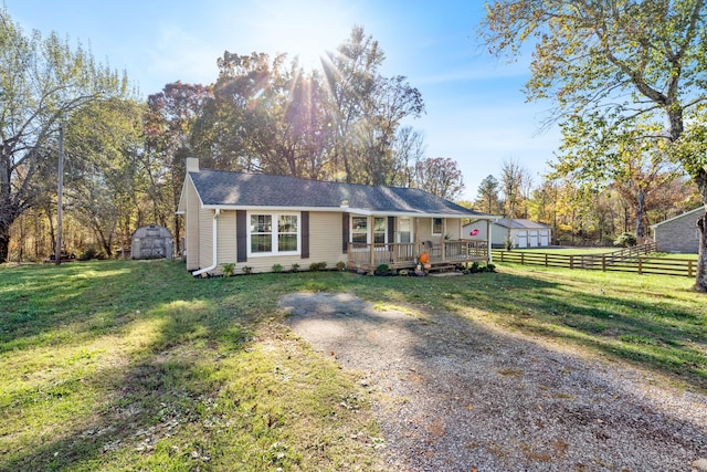 view of front of home with an outbuilding, a chimney, a storage shed, a front yard, and fence