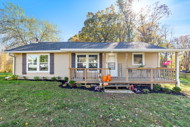 ranch-style house featuring a porch, a front lawn, a chimney, and a shingled roof