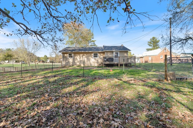 rear view of property featuring a fenced backyard, a lawn, and a wooden deck